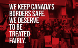 Picture of demo in front of Morneau's office in Toronto stating "We keep Canada's borders safe. We deserve to be treated fairly"