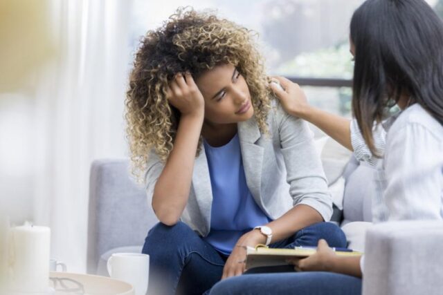 photo of a woman comforting another